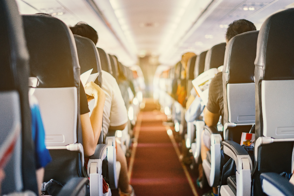 Pasajeros sentados a ambos lados del pasillo de un avión